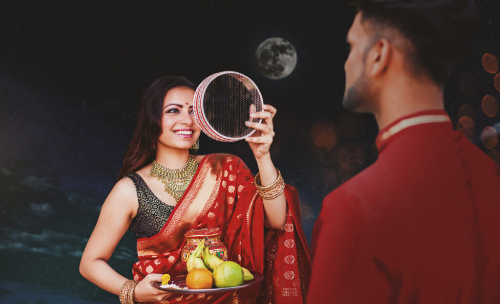 indian woman celebrating karva chauth by looking her husband night