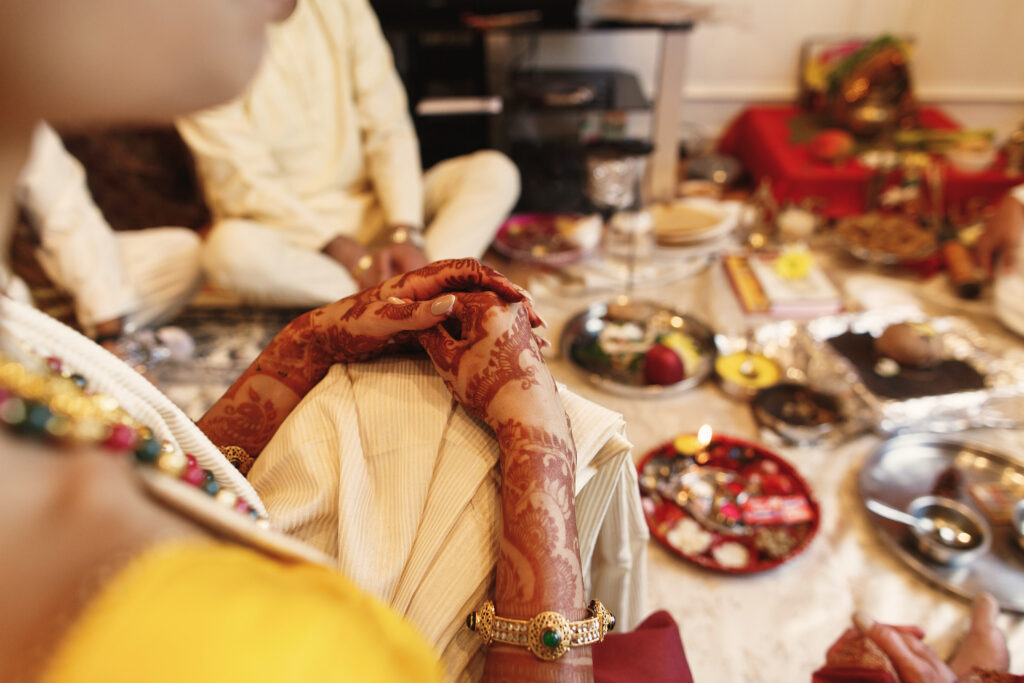 The Deeper Purpose of Authentic Brahmin Catering in Sacred Events woman lies her beautiful hands covered with mehndi over her knee