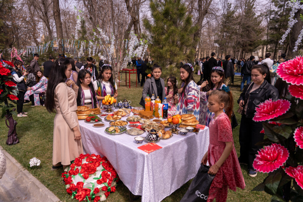 a group of people are gathered around a table with food on it