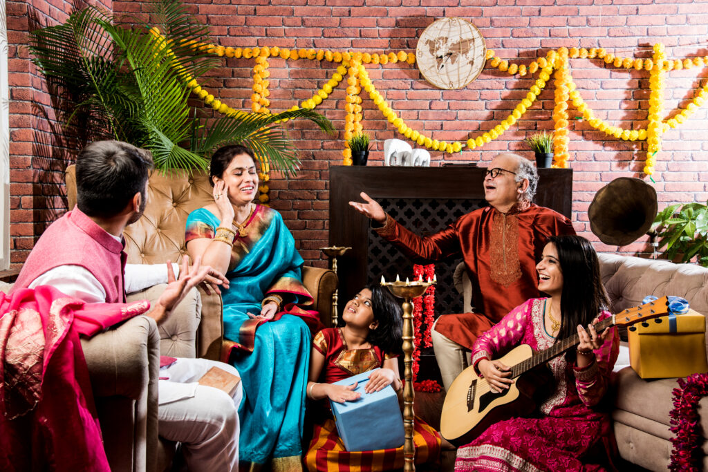 happy indian family singing, playing music, guitar while celebrating festivals in traditional cloths